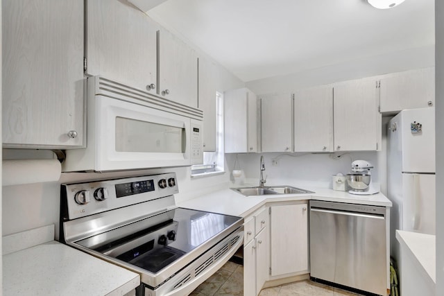 kitchen with light tile patterned floors, appliances with stainless steel finishes, and sink