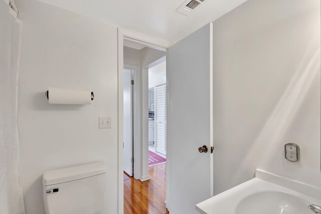 bathroom featuring toilet, sink, and hardwood / wood-style floors