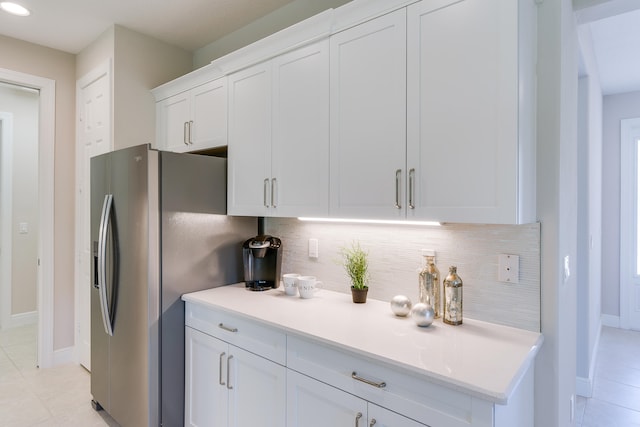 kitchen with tasteful backsplash, stainless steel fridge with ice dispenser, light tile patterned flooring, and white cabinets