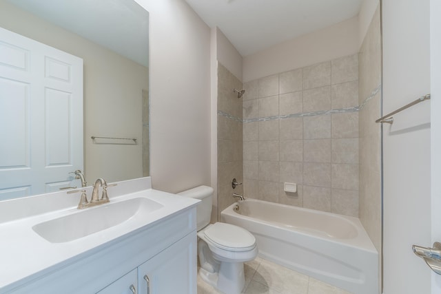 full bathroom featuring toilet, vanity, tiled shower / bath, and tile patterned flooring