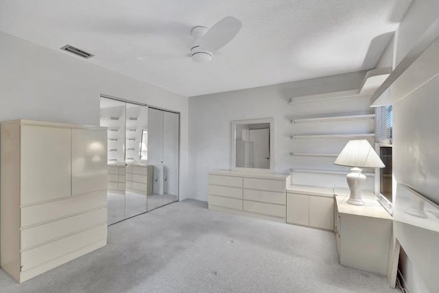 unfurnished bedroom featuring ceiling fan, a closet, and light colored carpet