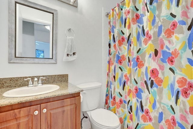 bathroom featuring a shower with shower curtain, vanity, and toilet