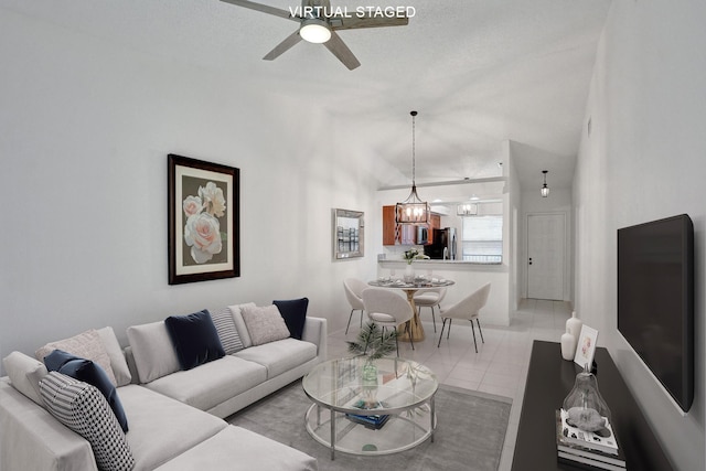 tiled living room featuring a textured ceiling and ceiling fan with notable chandelier