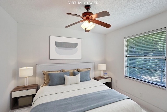 bedroom featuring ceiling fan and a textured ceiling