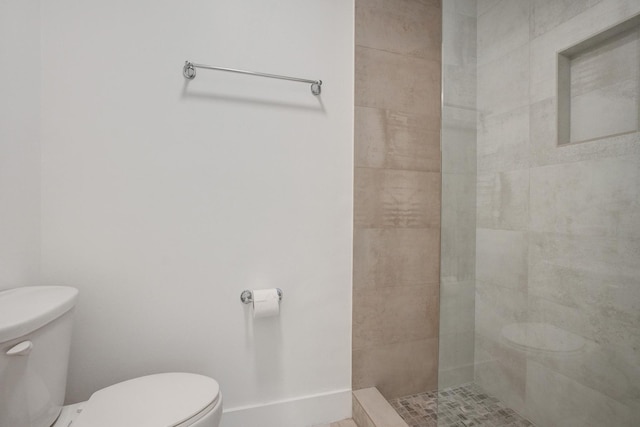 bathroom featuring toilet and tiled shower