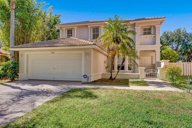 mediterranean / spanish-style house featuring a garage and a front lawn