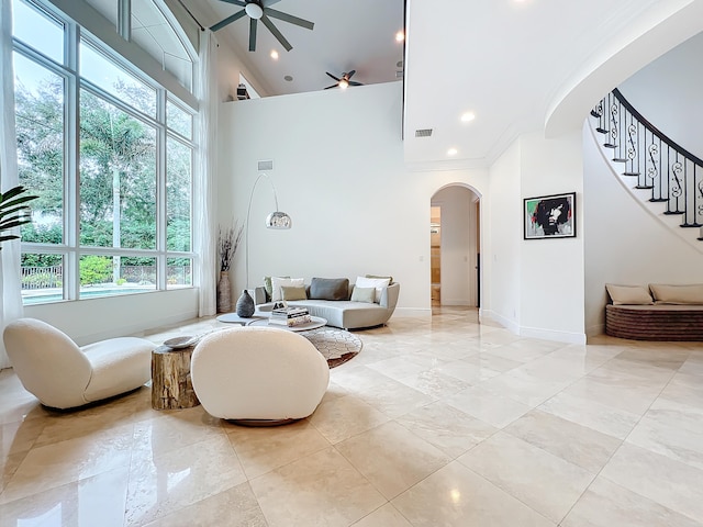 living room featuring ceiling fan, a healthy amount of sunlight, high vaulted ceiling, and ornamental molding