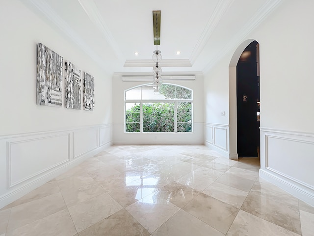 spare room featuring a raised ceiling and ornamental molding