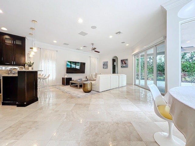 living room with ornamental molding and ceiling fan