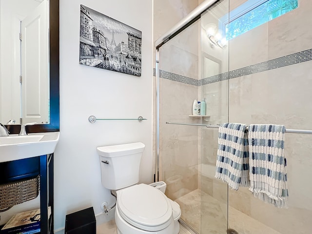 bathroom featuring toilet and a shower with shower door