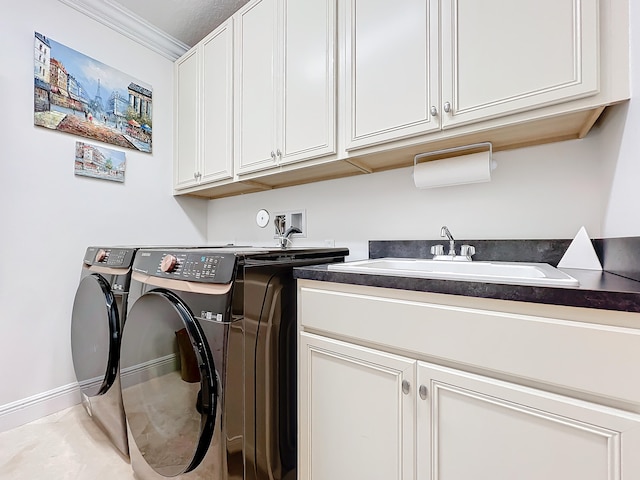 clothes washing area with cabinets, sink, washer and dryer, and ornamental molding