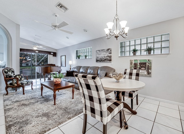 tiled dining room featuring ceiling fan with notable chandelier and lofted ceiling