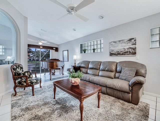 tiled living room featuring ceiling fan and vaulted ceiling