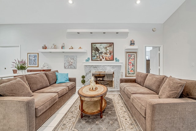 tiled living room featuring a high end fireplace and lofted ceiling