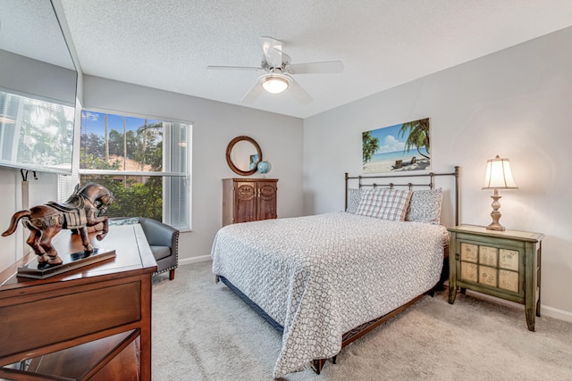 carpeted bedroom with a textured ceiling and ceiling fan