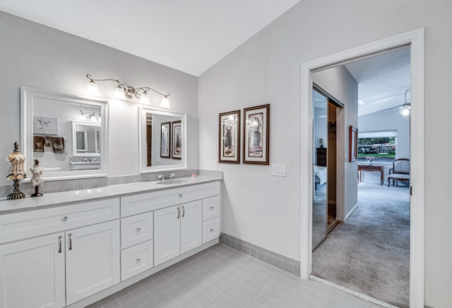 bathroom featuring tile patterned floors, ceiling fan, vanity, and lofted ceiling