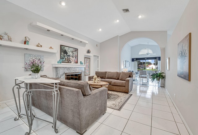 tiled living room featuring a high end fireplace and lofted ceiling