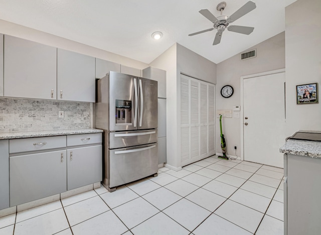 kitchen featuring ceiling fan, stainless steel fridge, light tile patterned flooring, and lofted ceiling