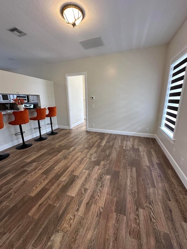 unfurnished office featuring dark hardwood / wood-style floors and a textured ceiling