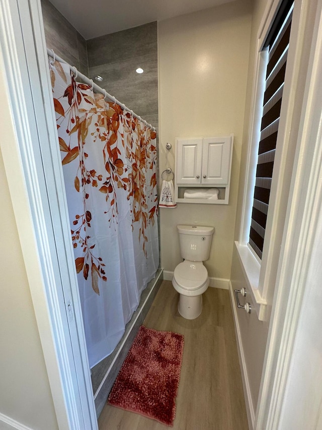 bathroom featuring toilet, wood-type flooring, and a shower with shower curtain