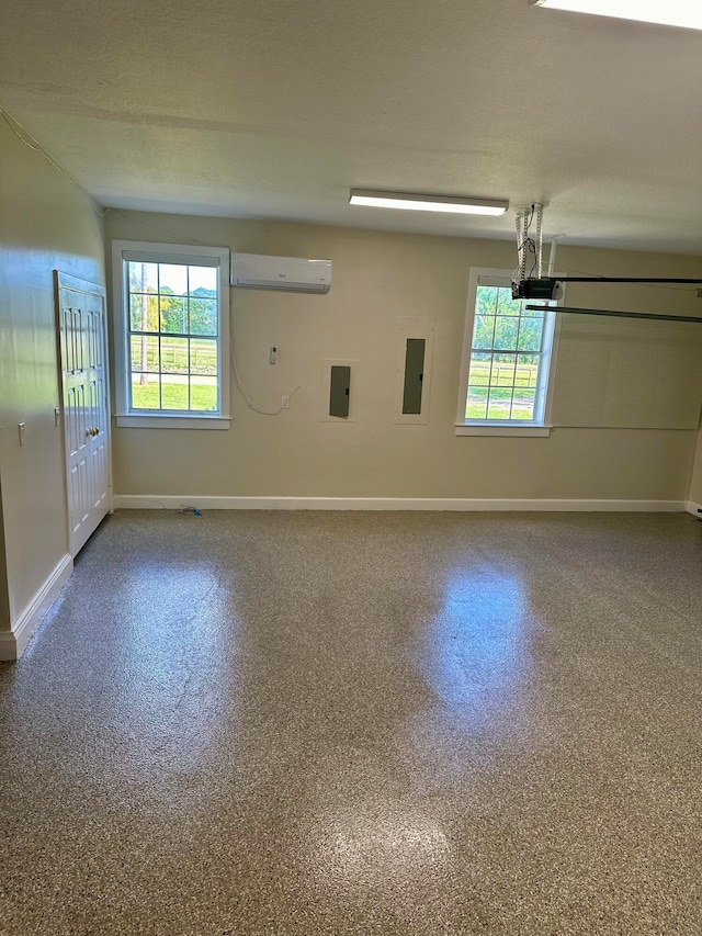 empty room with electric panel, a wall mounted air conditioner, and plenty of natural light