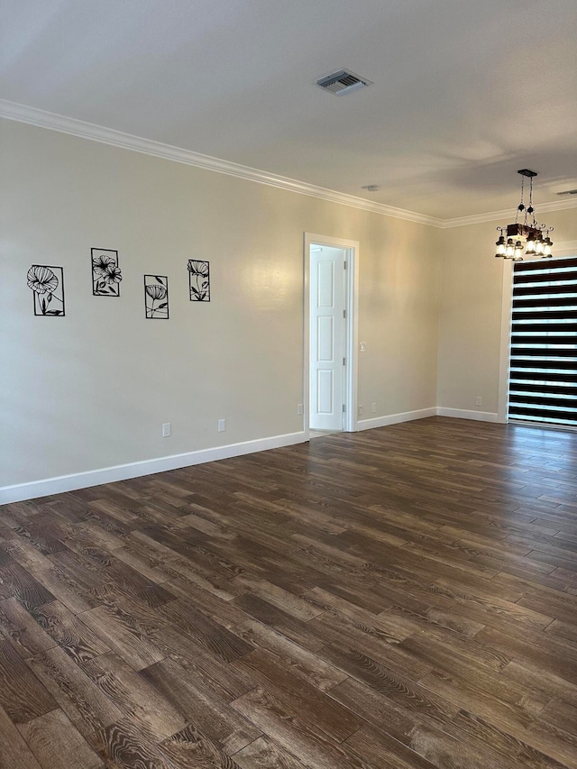 spare room with ornamental molding, a chandelier, and dark hardwood / wood-style floors