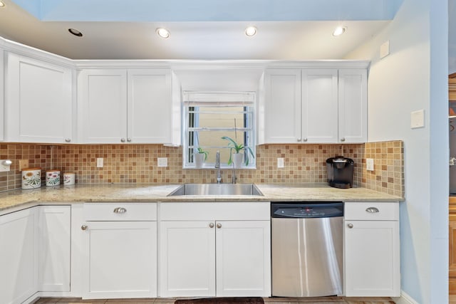 kitchen with backsplash, light stone counters, stainless steel dishwasher, sink, and white cabinetry