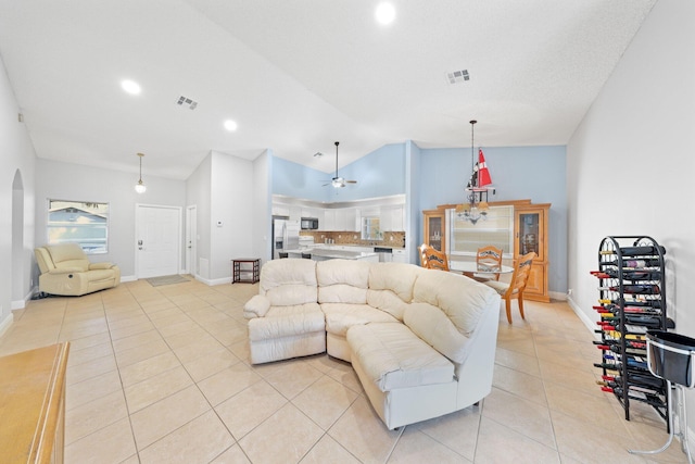 living room with ceiling fan, light tile patterned floors, and lofted ceiling