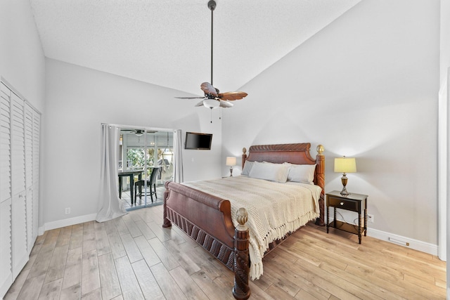 bedroom featuring ceiling fan, high vaulted ceiling, wood-type flooring, and a textured ceiling