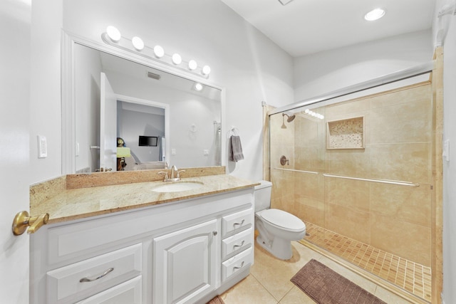 bathroom featuring tile patterned flooring, vanity, a shower with door, and toilet