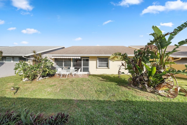 rear view of property featuring a yard and a sunroom