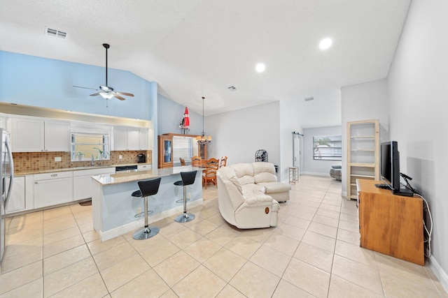 living room featuring ceiling fan, light tile patterned floors, and high vaulted ceiling