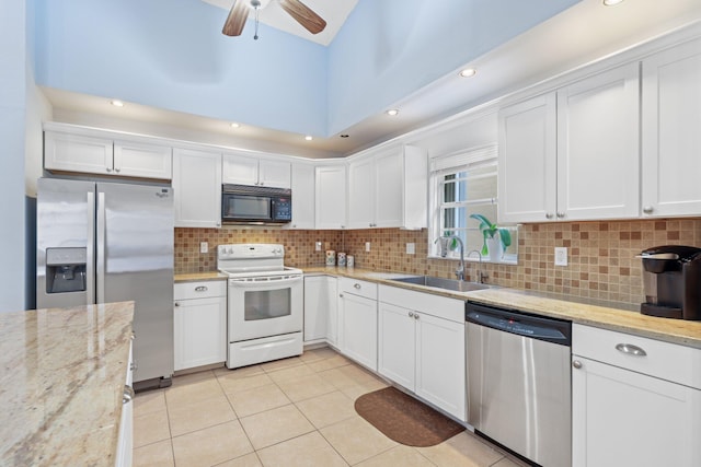 kitchen featuring white cabinets, stainless steel appliances, and light stone counters