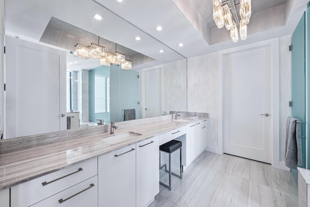 bathroom featuring double vanity, an inviting chandelier, a sink, and recessed lighting