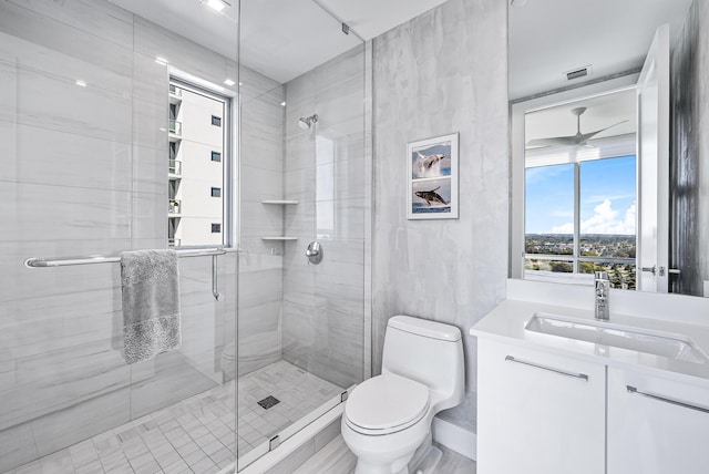 bathroom with vanity, toilet, a shower with door, and tile walls