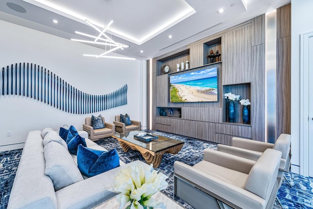 living room with a chandelier and a raised ceiling