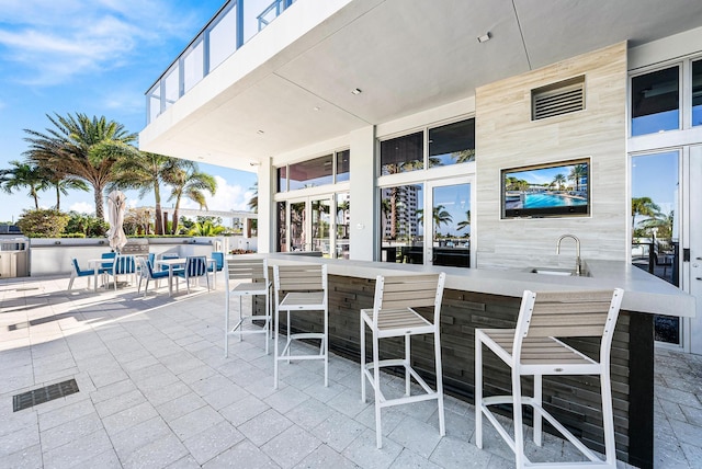 view of patio / terrace featuring visible vents, a sink, and a bar