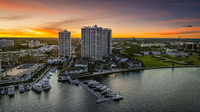 aerial view at dusk with a water view and a view of city