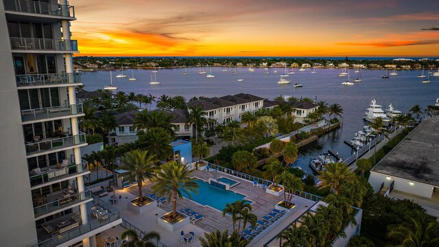 aerial view at dusk featuring a water view