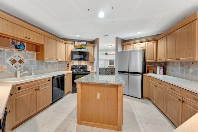 kitchen featuring a center island, black appliances, sink, tasteful backsplash, and light tile patterned floors