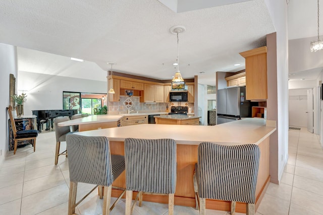 kitchen featuring pendant lighting, kitchen peninsula, black appliances, and a kitchen breakfast bar