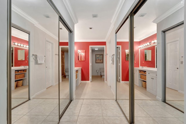 hall featuring light tile patterned floors and crown molding