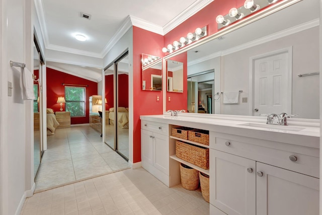 bathroom with ornamental molding, vanity, tile patterned floors, and lofted ceiling