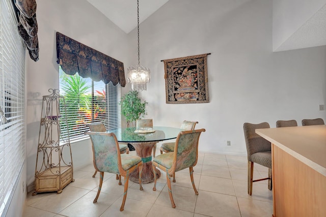 dining area featuring light tile patterned flooring, an inviting chandelier, and high vaulted ceiling