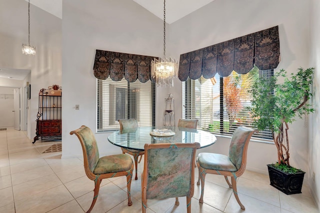 tiled dining room with high vaulted ceiling and an inviting chandelier