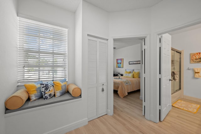 hall featuring a textured ceiling and light hardwood / wood-style flooring