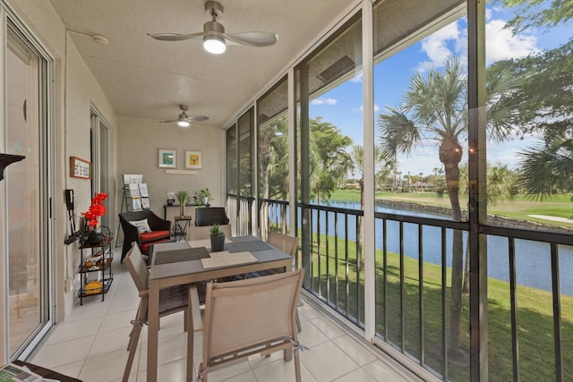 sunroom featuring a water view and ceiling fan