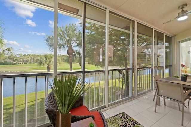 sunroom with a water view and ceiling fan