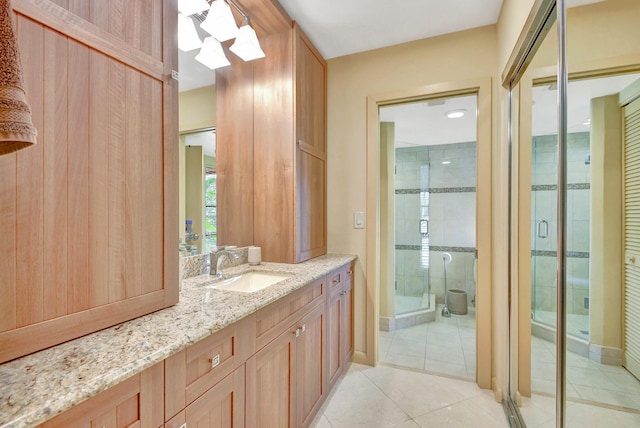 bathroom featuring walk in shower, tile patterned flooring, and vanity