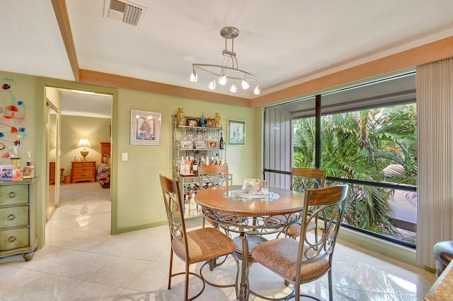 tiled dining room featuring an inviting chandelier